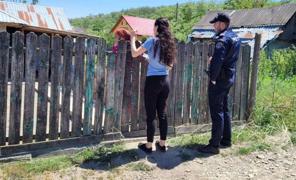 Unul din membrii asociației si un polițist vorbind cu oamenii